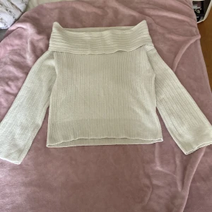 Offshoulder ribbad tröja från Nelly - Superfin offshoulder tröja från Nelly i ribbstickad vit färg. Tröjan har långa ärmar och en bred, vit krage som ger en snygg och trendig look. Perfekt att styla med jeans eller kjol för en chill vibe.