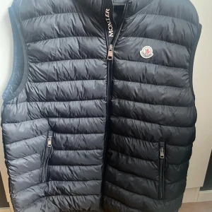 Svart dunväst från Moncler storlek 6 - Snygg svart dunväst från Moncler med klassisk quiltad design säljs på grund av att den har blivit för stor efter gått ner i vikt kan hämtas vid dörren eller skickas med post nord för 59kr hör gärna av er med frågor 👍🏻