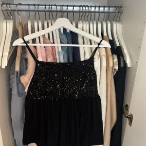 Svart paljettlinne från Gina Tricot - Supersnygg svart linne-topp från Gina Tricot med tunna axelband och glittriga paljetter över hela överdelen. Använt en gång❤️skriv för prisförslag eller fler bilder❤️❤️. Tryck gärna på köp nu