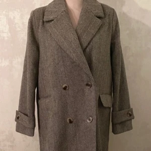 Vila - viHynda - Gråmelerad kappa med fiskbensmönster stl.S - Stilren gråmelerad kappa i klassiskt fiskbensmönster med dubbelknäppning och breda slag. Jackan har långa ärmar med knappar vid ärmslut och två fickor framtill.  Som ny - använd endast ett fåtal gånger.   Storlek S.  Ledig, rak modell   • Stor krage med slag  • Passpoalfickor med lock  • Dekorativ slejf på ärmen  • Sprund nedtill bak  • Axelvaddar  • Fodrad  • Längd: 97 cm i storlek 36    Kvalitet: Vävd Foder: 100% Polyester Material: 80% Polyester, 20% Ull Tvättråd: Ej vattentvätt 