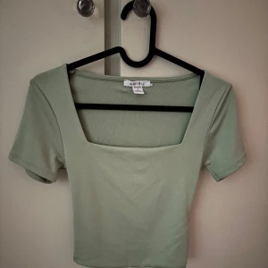 Ljusgrön croppad topp från Amisu - Säljer en ljusgrön croppad topp från Amisu med fyrkantig ringning och korta ärmar.✨