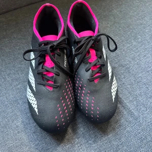 Adidas Predator fotbollsskor svart/rosa - Säljer ett par Adidas Predator fotbollsskor som tyvärr inte hann användas så mycket av mig förens jag blev skadad. Har använt dom 2-3 gånger så nästa som nya.💖