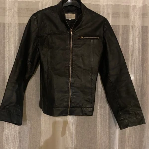 Svart skinnjacka från KIT - Säljer en snygg och tidlös svart skinnjacka från KIT Contemporary Clothing. Storlek S , äkta läder. Fått i present men aldrig använt då jag inte passar i den