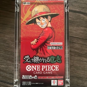 One Piece Card Game OP-13. Carrying on His Will.(Japansk) - Upptäck One Piece-världen med detta samlarkortspel! Perfekt för fans av manga och anime, med 132+1 unika kort och cool design inspirerad av Luffy och besättningen. Utmana vänner och bygg din egen piratstrategi. För dig som älskar äventyr och spänning! Innehåller 24 pack och 6 kort per pack.