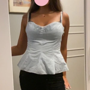 Blåvit randig korsettopp från Zara - Supersöt korsett aktig topp från zara i nyskick med prislapp kvar. Den är blå vit randig med en rosett och vita spets detaljer. I storlek M
