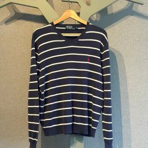 Randig tröja från Polo Ralph Lauren - Mörkblå stickad tröja från Polo Ralph Lauren. Ett gött plagg nu till hösten som kan ge din outfit ett lyft🔥OBS! Denna tröja är storlek M men passar nog också S!