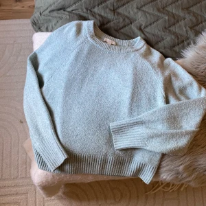 blå/ grön stickad tröja från H&M - Mysig ljusblå stickad tröja från H&M med rund halsringning och ribbade muddar vid ärmslut och nederkant. Perfekt för lager-på-lager och chill dagar. Enkel och stilren design som passar till det mesta.