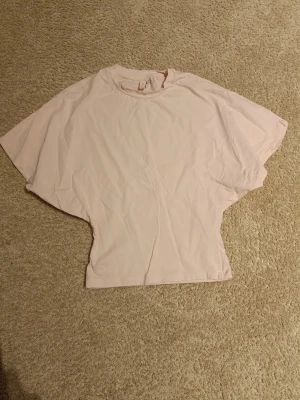 Tshirt från nelly - Tshirt från nelly som går in i midjan.