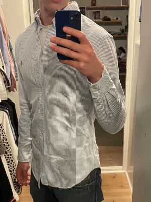 Ralph Lauren skjorta i nästintill nyskick med stripes! - En riktigt stilren Oxford raffe skjorta i mycket bra skick för ett riktigt bra pris, fler bilder kan skickas vid efterfrågan:) Stryker den innan jag postar den så den är redo för användning när den kommer fram:) Pris kan diskuteras vid snabb affär.