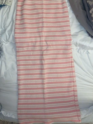 Rosa och vit randig långkjol - Säljer en söt långkjol med rosa och vita ränder. Kjolen har en rak passform och är gjord i ett mjukt stickat material som känns riktigt skönt mot huden. Aldrig använt 