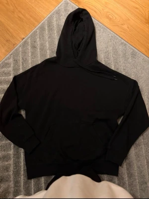 Svart hoodie från FBsisters  - Svart hoodie från FBsisters – XS (stor i storleken) unisex En klassisk svart hoodie som passar både tjejer och killar. Storlek XS och i bra skick. Perfekt för vardag, skola eller mysiga hemmadagar 