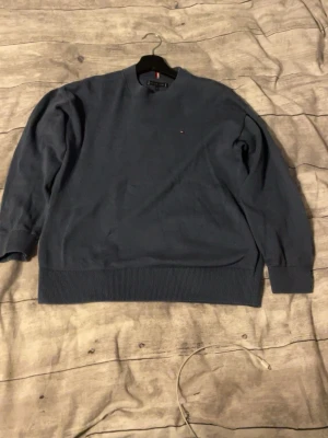 Mörkblå tröja från Tommy Hilfiger - Snygg blå tröja från Tommy Hilfiger med diskret logga på bröstet.Tröjan är Perfekt för dig som gillar klassisk stil med en modern touch.