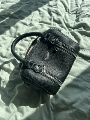 Svart handväska Zadig & Voltaire - Säljer en svart handväska från Zadig & Voltaire i snyggt skin. Modellen är mini Sunny bag. Axelband medföljer. Utsidan ser helt ny ut men insidan har tyvärr fått bläck i sig. Perfekt storlek för att packa med det nödvändigaste till fest eller skolan. Hör gärna av er vid frågor. ❤️❤️❤️