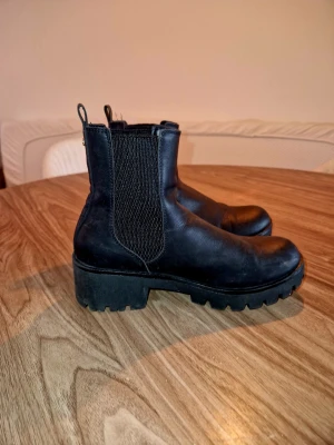 Svarta chelsea boots i skinn, stl 37 - Säljer ett par svarta chelsea boots i skinn med grov sula och elastiska partier på sidorna. Använt 1 gång 