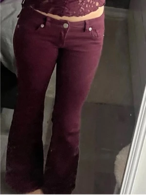 Vinröda bootcut jeans - Säljer ett par vinröda jeans med bootcut lågmidjade .jeanswn finns nästan inte att få tag i, storlek 34