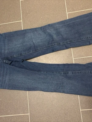 Mörkblå jeans från Gina Tricot - Säljer ett par klassiska mörkblå jeans från Gina Tricot i storlek 158. Jeansen är bootcut och normal passform, tillverkade i mjukt denimtyg. Perfekta till en avslappnad look och funkar året runt.