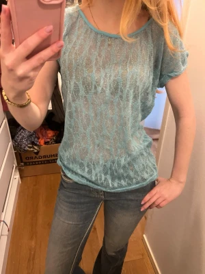 Turkos blå glittrig genomskinlig topp - T-shirt som är genomskinlig och glittrig, känns som S