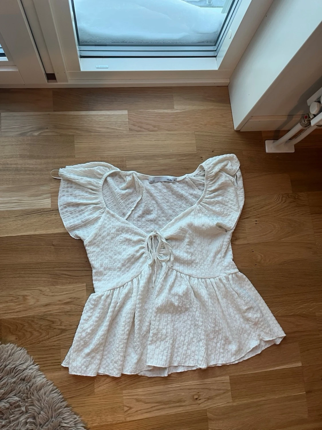 Vit blus med knyt och volang