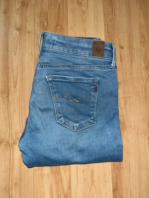 Replay Hyperflex jeans  - Säljer ett par Replay Hyperflex jeans i ljusblå tvätt. Modellen är skinny fit med stretchigt material för extra komfort. OBS jeansens tyg har blivit lite förtunnat både baktill vid ena fickan & skrevet. Midja 32cm, längd 101cm. JAG SKICKAR EJ FLER BILDER NÄR JAG BÄR JEANSEN! för bättre inblick i passformen rekommenderar jag att googla på modellnamnet. För storleksguide kolla måtten noggrant då jeansen alltid kan vara uppsydda heller krympta och jag ej tar emot returer :) 1,10
