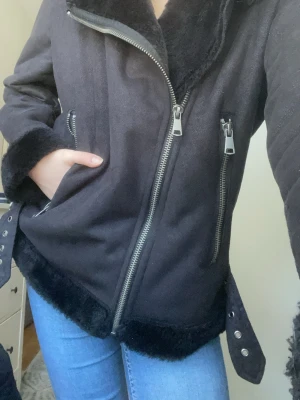 Svart pälsjacka med dragkedjor - Säljer en svart läderjacka med pälsmaterial inifrån från Lindex. Skön och behaglig, men lite för stor för mig!! Inte mycket använd, köpt i butik. Pris går att förhandlas. 