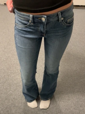 Blå lågmidjade bootcut jeans H&M Divided - Ett par blå bootcut jeans från H&M Divided i storlek 32. Är lite tvättad framtill. Aldrig använda.