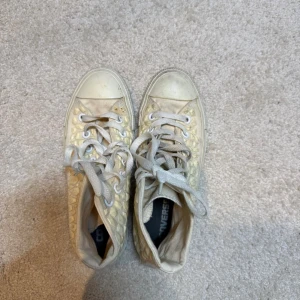Vita Converse sneakers med 3D-mönster - Unika vita Converse high-top sneakers med coolt 3D-mönster på sidorna. Klassisk rund tå, vita snören och gummisula. Skorna har en upphöjd struktur som ger extra edge till din stil. Perfekta för dig som vill sticka ut med dina sneakers. OBS ‼️ smutsiga på vissa ställen, bör dock att kunna gå att få bort om man putsar till dem