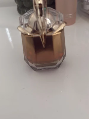 Alien Goddess Intense Eau de Parfum - Snygg parfym från Mugler i en unik, guldtonad flaska. Perfekt för dig som vill ha en exklusiv touch på sminkbordet. Märket syns tydligt på flaskan. Volym och ingredienser framgår ej.