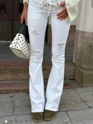 Trendiga vita Gina jeans! - Säljer ett par vita bootcut jeans med låg midja och snygga slitningar på låren. Säljer för 500 då dom är slutsålda och har endast använt en gång!