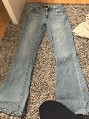 Ljusblå bootcut jeans - Säljer ett par ljusblå jeans med klassisk bootcut passform. Jeansen har fem fickor, normal midja och är tillverkade i mjukt denimtyg. Perfekta för dig som gillar en retroinspirerad look med utsvängda ben.