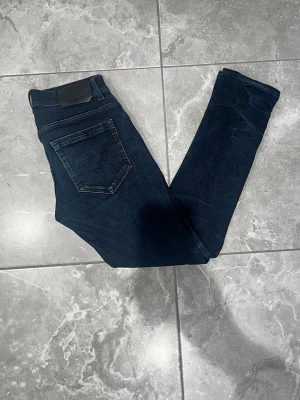 Dondup jeans - Dondup jeans i snygg mörkblå färg, modellen är George och skinny fit. Tillverkade i mjukt bomullsmaterial med en stilren look som passar till det mesta. Storleken är i W30