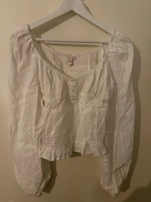 Långärmad vit topp - Jätte fin långärmad vid topp från Nelly. Super fin på fest men även en helt vanlig dag