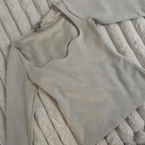 Vit långärmad topp H&M - Säljer en stilren vit topp med lång ärm och unik fyrkantig ringning. Toppen har en mjuk och slät yta, figurnära passform och är perfekt för dig som gillar minimalistisk stil. Passar till både jeans och kjol.