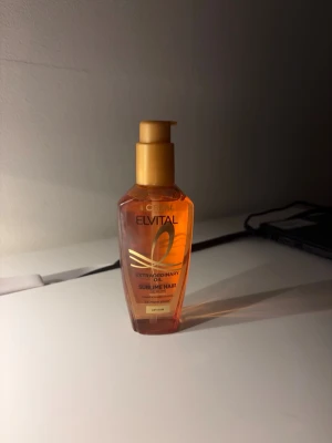 L'Oréal Elvital Extraordinary Oil - L'Oréal Elvital Extraordinary Oil Sublime Hair Serum i en snygg orange plastflaska med pump. Innehåller kameliaolja och ger extra glans till torrt hår. Flaskan rymmer 100 ml och har guldfärgad pump. Perfekt för dig som vill ha mjukt och glansigt hår.
