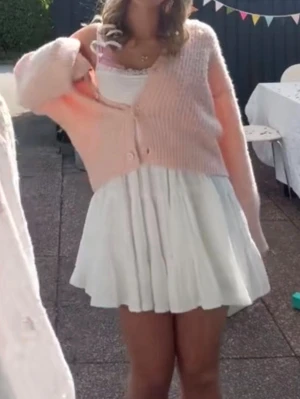 Vit kort sommarklänning med spets - Supersöt vit kort klänning med tunna axelband och volangig kjol. Överdelen är smockad och har en fin spetskant vid urringningen. Perfekt för varma dagar och ger en romantisk vibe. Luftigt material som känns lätt och skönt på kroppen.