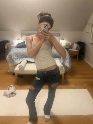 Mörkblå slitna bootcut jeans - Säljer ett par mörkblå jeans med bootcut och slitna detaljer över knäna. Jeansen har låg midja och klassisk femficksdesign. Jeansen är från LTB i storlek 25/36😊 Kom gärna med pris förslag!