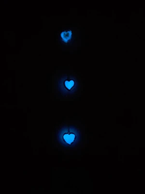 FROSTY HEARTS – Handmade Glow Sun-catcher ❄️✨ - Unik handgjord solfångare! Tre vita hjärtan som lyser magiskt blått i mörker/UV efter laddning i ljus. Det första hjärtat har en handplacerad grön blomma inuti. Stilren inredning för fönstret! ​Detaljer: ​Längd: 33 cm ​Material: Rostfritt stål (kedja) ​Skick: Nytt/Egen design