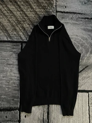 Produkt half zip - Säljer en svart stickad tröja från Produkt i storlek M. Tröjan har en hög krage med half zip-dragkedja och långa ärmar. Enkel och stilren design som passar perfekt till lager på lager under höst och vinter.