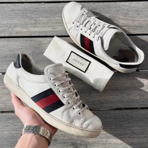 Gucci Ace - Gucci Ace till riktigt bra pris! Skick 7,5/10, sliten häl men inger som känns vid användning, annars bra skick. Dustbag ingår. Us 9,5 passar 44. Kontakta mig för fler frågor och funderingar!