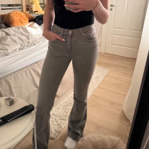 Grå bootcut jeans från Gina Tricot  - Snygga grå jeans från Perfect Jeans i bootcut-modell med medel hög midja. Jeansen har klassisk femficksdesign, dragkedja och knapp framtill. Materialet är stretchigt jeans för en bekväm passform. Perfekta för dig som gillar en stilren och trendig look. Använt väldigt få gånger, säljer då de inte kommer till användning🍁🍂