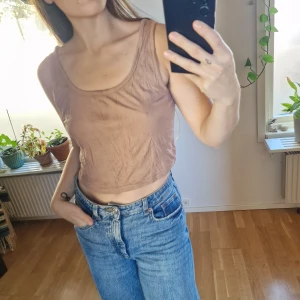 Ribbad ljusbrun croppad linnetopp - Kamelfärgad topp i ribbat tyg. Olika ljus på alla bilder för bra representation av hur den ser ut.