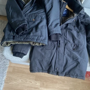 Svart parkajacka från Svea,S.tvillingar  - Säljer 2 nästan likadana mycket bra skick svart parkajacka vindtät från Svea med ribbade muddar, dragkedja och knappar framtill. Jackan har flera fickor med lock och en snygg patch på ena ärmen. Fodret är beige och jackan är perfekt för kalla dagar.hämtas i norsborg botkyrka eller fraktas. Har 10 andra fina jackor skicka pm tack .750kr/st