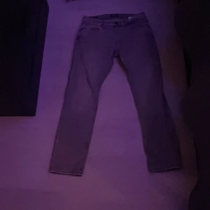 Grå jeans från Jack n Jones  - Snygga grå jeans från Tapered/Mike med klassisk femficksdesign och bälteshällor. Jeansen har en tapered passform som smalnar av nedtill och är tillverkade i slitstarkt jeanstyg. Perfekta för dig som gillar en modern och avslappnad stil.