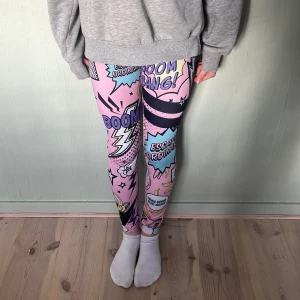 Stronger leggings - Färgglada leggings från Stronger i rosa, blått, svart och gult. Hög midja med logotyp i midjebandet och tight passform. 