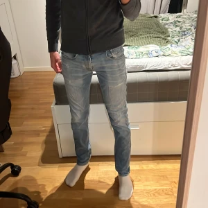 Replay ljusblå slim jeans, storlek 27 - Säljer ett par ljusblå Replay jeans i slim fit med snyggt slitna detaljer och klassisk femficksdesign. Jeansen har dragkedjegylf, Replay-logga på fickan och är tillverkade i mjukt denimtyg som sitter tajt men bekvämt.