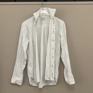 Schyst vit skjorta från Oscar Of Sweden - Vit Oscar Of Sweden skjorta med mörka tunna ränder, är en slim-fit i storlek M 