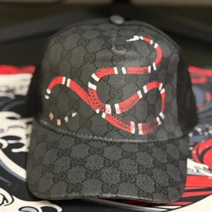 GG keps med orm tryck - En snygg svart GG keps med orm tryck. Är helt ny och oanvänd.