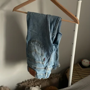 Levi's  ljusblå jeans straight fit - Klassiska Levi's jeans i ljusblå denim med raka ben och normal passform. Byxorna har fem fickor, knappgylf och den ikoniska läderpatchen bak i midjan. Perfekta för en avslappnad och tidlös stil. Storlek 150-160. Skriv vid minsta fundering 