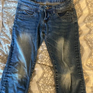 Blå jeans från TON Jeans - Snygga blå jeans från TON Jeans med klassisk femficksdesign och slitningar framtill för en cool look. Jeansen har normal passform och raka ben. Perfekta för dig som gillar en avslappnad stil. Materialet är robust denim i bomull.