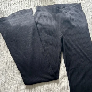 Svarta ribbade bootcut-byxor Divided - Svarta ribbade byxor från Divided, H&M. Byxorna har bootcut-modell med utsvängda ben och är tillverkade i stretchigt material med 91% polyester och 9% elastan. Snygg passform och bekväm midja, perfekta till din vardagsstil.