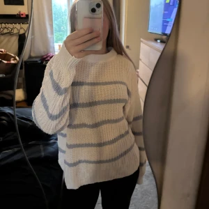 Vit stickad tröja med blåa ränder - Vit stickad tröja från 157 i storlek M. Tröjan har ljusblå horisontella ränder och en rund halsringning. Superskön nu till hösten och passar perfekt till jeans eller en kjol. Tröjan är lite smått stor i storleken men passar bra! Näst intill ny då den knappt är använd.